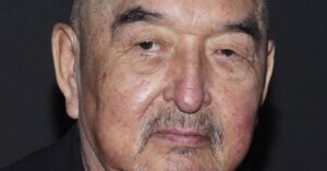 Oscar-nominated actor Graham Greene performing on stage with microphone